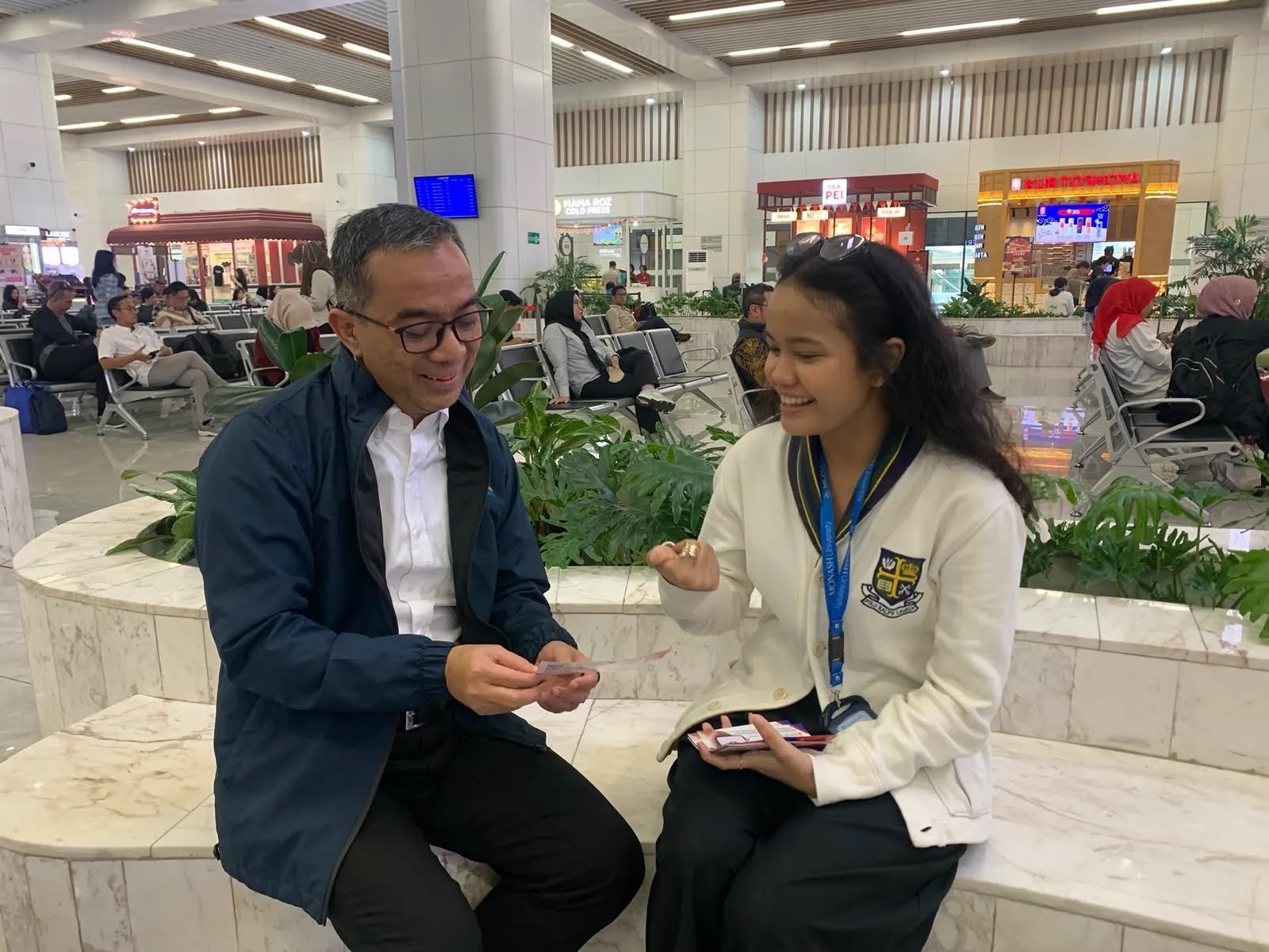 Indonesia's Minister of Higher Education, Science and Technology reading a Whoosh passenger survey flyer with a Monash researcher at Halim HSR Station